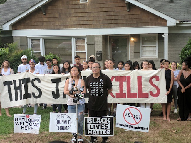 Cat Bao Le (left) and Tin Nguyen stand with community support outside of their home. (Photo by Ryan Pitkin)