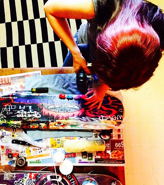 Phoebe Alicia constructing her art, which is wheat-pasted on skateboards. (Photo by Phoebe Alicia)