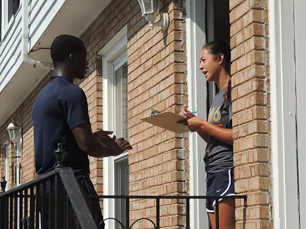 Diaby speaks with a woman while canvassing in east Charlotte. (Photo by Ryan Pitkin)