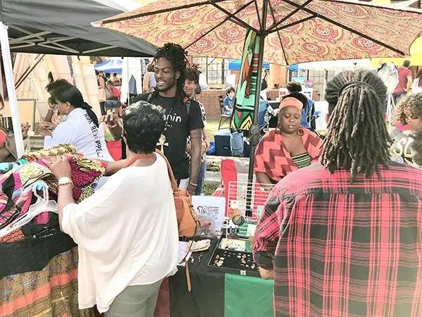 Ali Steele (in black T-shirt) sells his designs at the Oct. 21 Bla/Alt Music Festival at Camp North End. (Photo by Mark Kemp)