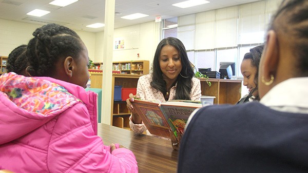 Nikki Davis reading books with kids at local schools, where she often visits. (Photo courtesy of I'Merge)