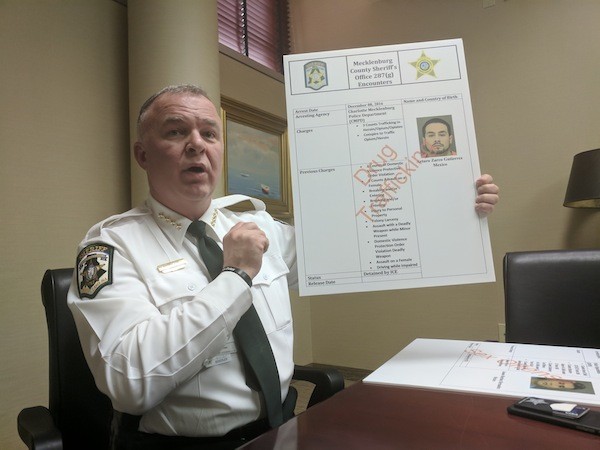 Sheriff Irwin Carmichael shows one of multiple posters he’s made highlighting the crimes of folks who have been flagged and deported through the 287(g) program.
