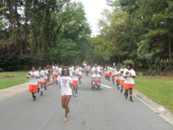 The Vance High School band marches through the streets of Hidden Valley during the community’s 24th annual parade and festival, titled “From Gangs to Greatness” this year. (Photo by Ryan Pitkin)