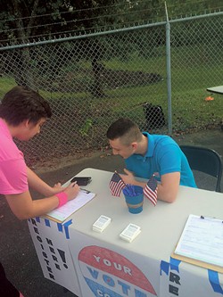 Chris Deitch (in blue) with one of the students he’s gotten registered since beginning his efforts in Fall 2015. (Photo courtesy of Chris Deitch)