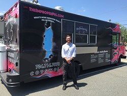 Gavin Toth posing with The Improper Pig's new food truck.