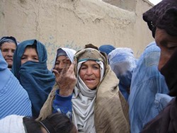 A woman outside an NGO office in Paghman, Afganistan, waiting in a long line to register for aid.