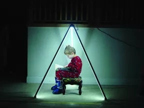 Andy Neal’s son Miles sitting inside a pyramid of ILLUMATUBES powered by flashlight batteries. - MICHAEL SIBILIA