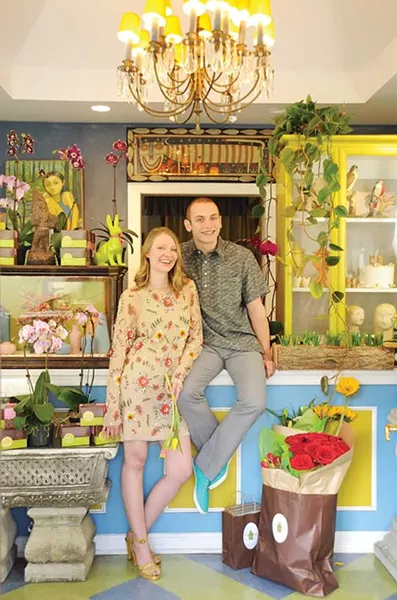 Cassandra Hansen-Patsch wearing an {EM} Reservoir embroidered hydrangea dress and Justin Heredia in {EM} Reservoir straight leg dress slacks with the wave hemp-blend pullover from Goose Organic. Clothing from Reservoir and Wood in Beacon. - KELLY MERCHANT
