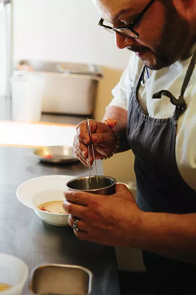 Chef Rei Peraza plating locally foraged ramps into a dish - THOMAS SMITH
