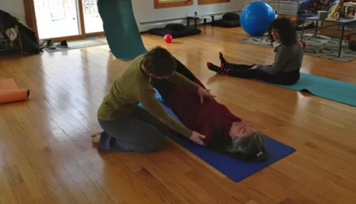 clyde forth adjusts a student in Pilates Community Class