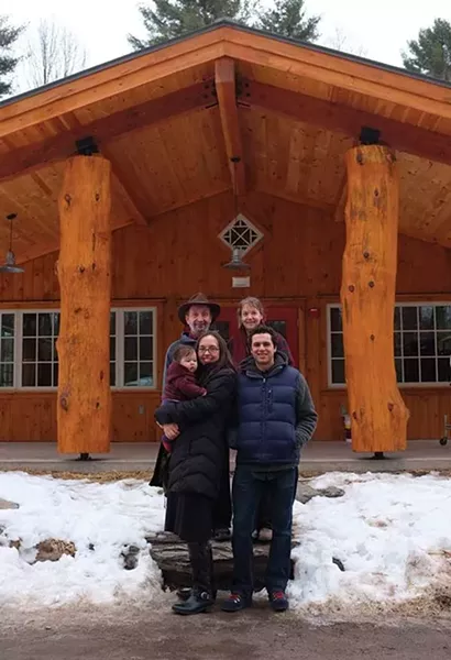 Jay Ungar, Molly Mason, Ruthy Ungar, Mike Merenda, and baby Opal Merenda in front of the dining hall at the new Ashokan Center in Olivebridge. - FIONN REILLY