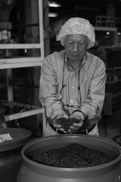 John Harney scoops blended tea. - TERESA HORGAN