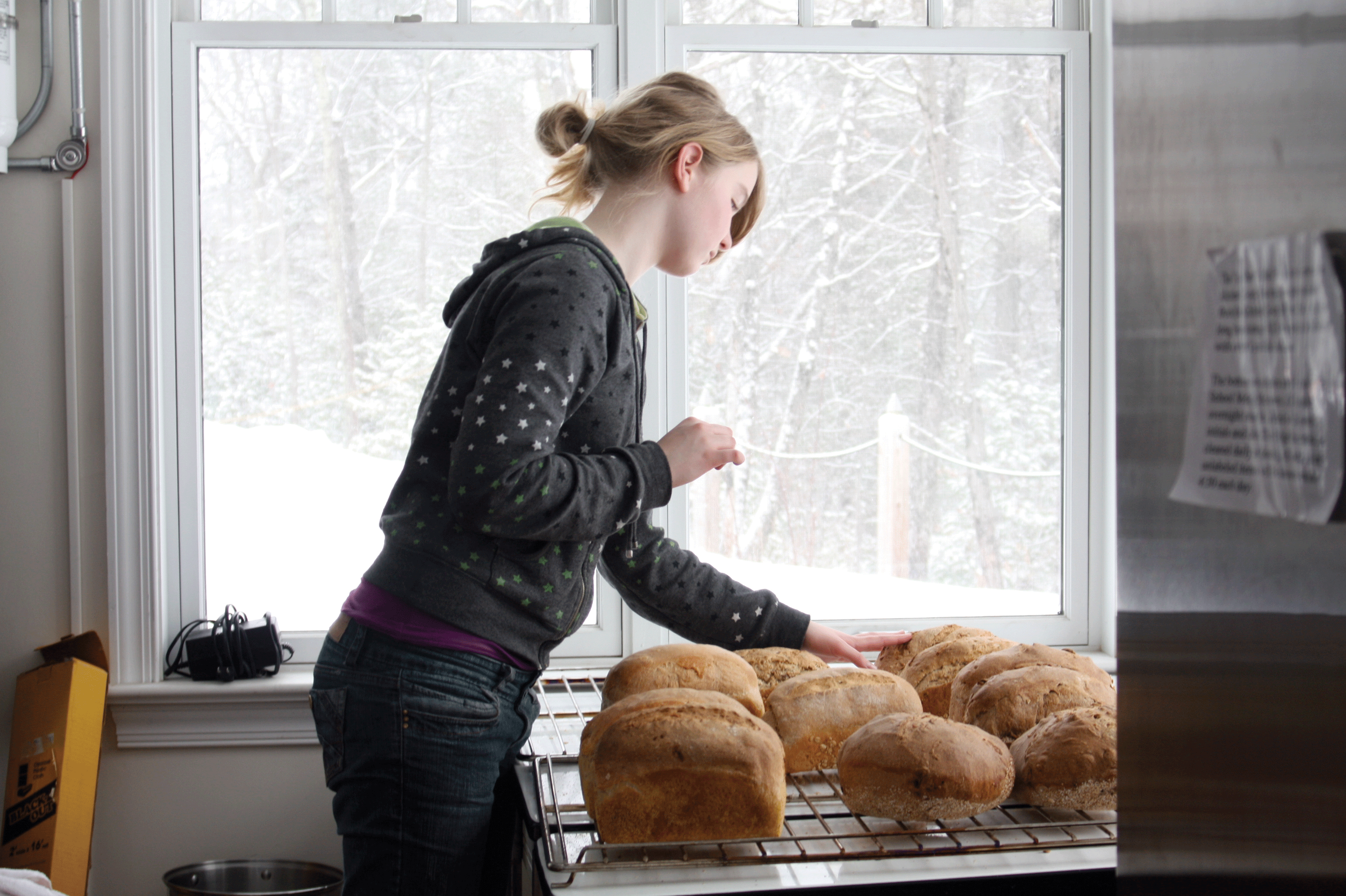 Lily, a student at the Hudson Valley Sudbury School in Woodstock, checking bread she baked as a fundraiser for her trip to England.