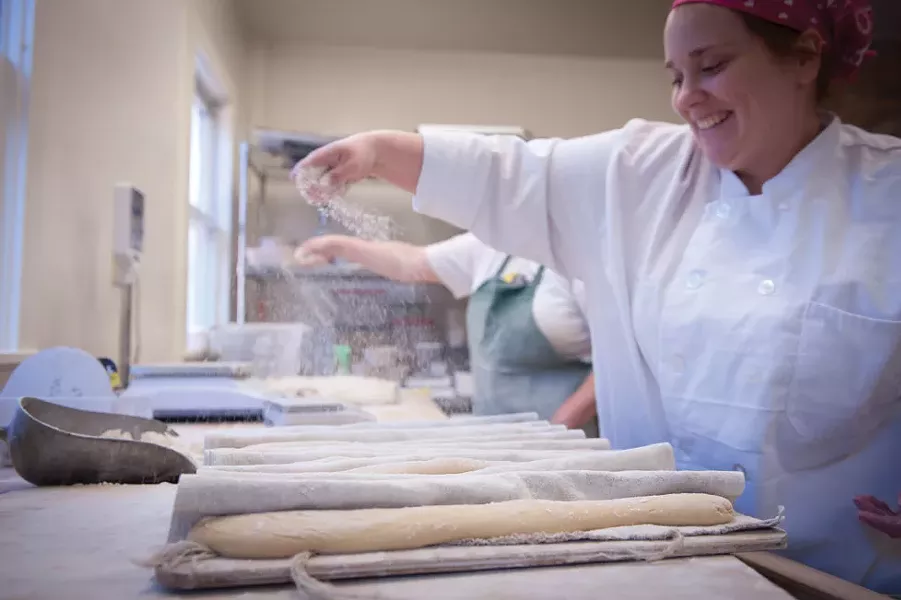 Nichole Cooley, head baker at Café le Perche, preparing baguette du Perche in the bakery. At 9:30am, this was the end of Cooley’s nine-hour shift. - JENNIFER MAY
