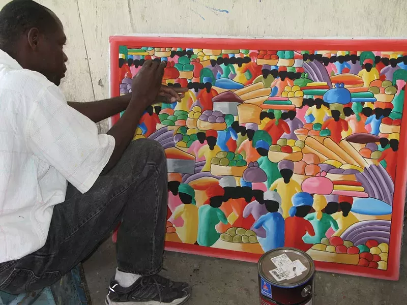 The artist Sonson putting the final touches on one of his works in Port-au-Prince.