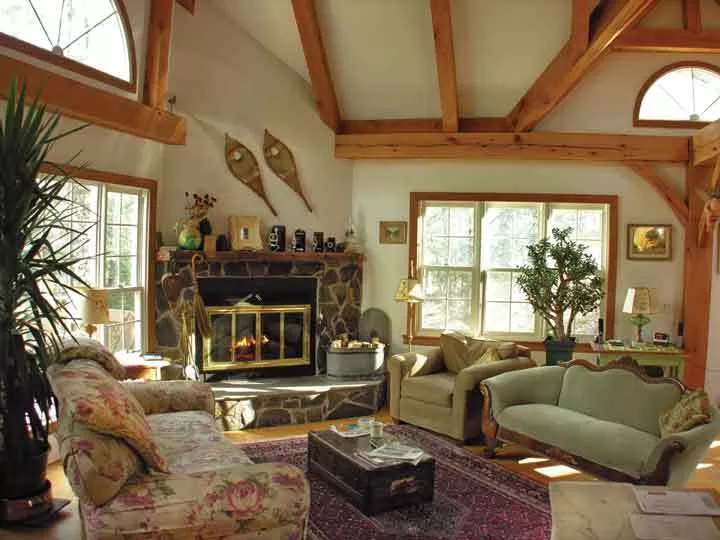 The Brandt’s living room, furnished with personal treasures like the mantel over the fireplace (salvaged from a demo site in Manhattan), snowshoes from a former house in Canada, and a fireplace built with stones selected from the property. - PETER BRANDT
