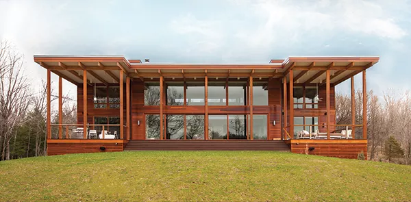 The dramatic large overhangs on the south wall facing the pond shield the home from unwanted summer solar gain, while the walls of glass provide passive solar heating in winter. Lindal’s signature Western Red Cedar siding complements the desi