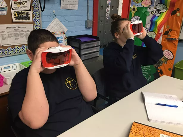 Two seventh-graders use VR googgles in class.