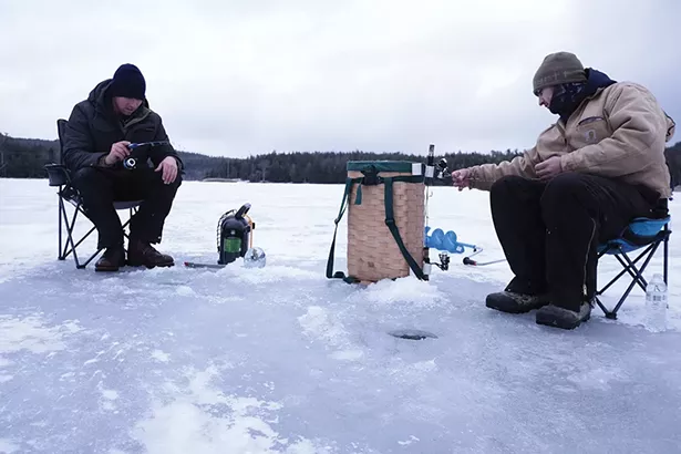 Kingston natives Brandon (left; he declined to give his last name) and Anthony Jansen fishing on North Lake, where the ice was seven inches thick. They’d been out since 4:30 in the morning, drilling holes and dropping lines as they moved down the shoreline. The two started fishing - together five years ago, after Anthony began dating Brandon’s sister. - PHOTO BY ROY GUMPEL