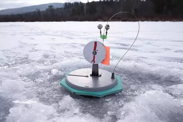 One of Sergey’s tip-ups, the device that sits over a hole in the ice and alerts anglers to a bite. When a fish takes the bait, the orange flag pops up. The angler then pulls in the line by hand. In his first hour on the lake, Sergey had caught four fish. - PHOTO BY ROY GUMPEL