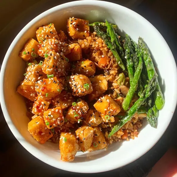 Vegan crispy tofu special with vegetable fried rice and chili sauce.