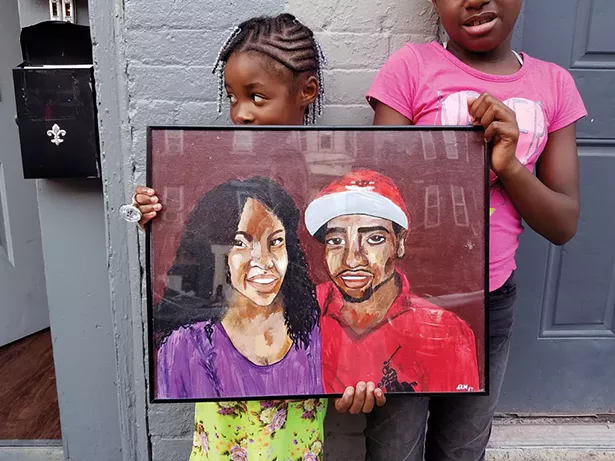 Relatives hold a painting of Gevontay Owens-Grant, who was killed at a Valentine’s party at 253 South William Street in Newburgh in February 2017. He’s pictured beside his fiancée, Demira Melvin. - PHOTO BY LAUREN BERG