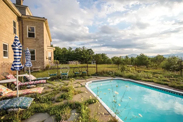 When she first moved in, Raimondo hired Simeon Lytle of - West Hurley and Kenny Herdman from Big Indian to install the fiberglass salt-water pool. She sourced antique wrought - iron fencing and gates online to complement the home’s stone exterior and often lets the wildflowers grow up between - the stone pavers to add to the property’s natural ambiance. - PHOTO BY WINONA BARTON-BALLENTINE
