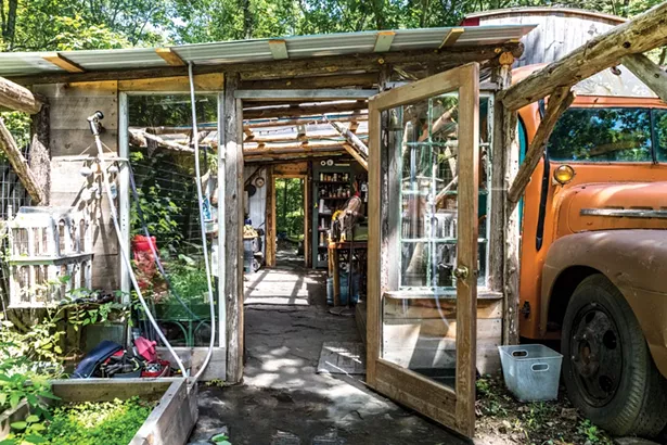 Adjacent to Quick’s bus, the couple built an outdoor kitchen with a clear plastic roof and a large fire pit nearby. They use both through the winter. “We are trying to be as off-grid as possible,” he says. - PHOTO BY WINONA BARTON-BALLENTINE