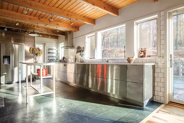 A complete renovation of the home’s outdated, enclosed kitchen was a priority. “I cook a lot,” explains Kant. “And I like to have space to work.” The couple removed overhead cabinetry, updated the appliances, and then replaced the fixtures and surfaces with an eye toward the “clean, plain, and modern,” leaving plenty of open counter space. - PHOTOS BY WINONA BARTON-BALLENTINE