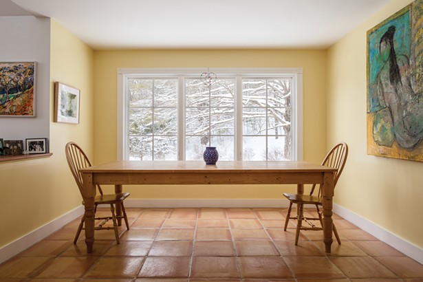 The home’s open dining area enjoys views to the adjacent meadow. Ylvisaker designed the space to easily sit 10 people around the pine farm table. A large painting by local artist Stephen Kerner hangs along one wall. Another smaller work by artist Judith Sobel hangs between the dining and living room. As a child, “Woodstock and the artists that convened at my grandmother’s table always intrigued me,” she says. - WINONA BARTON BALLENTINE