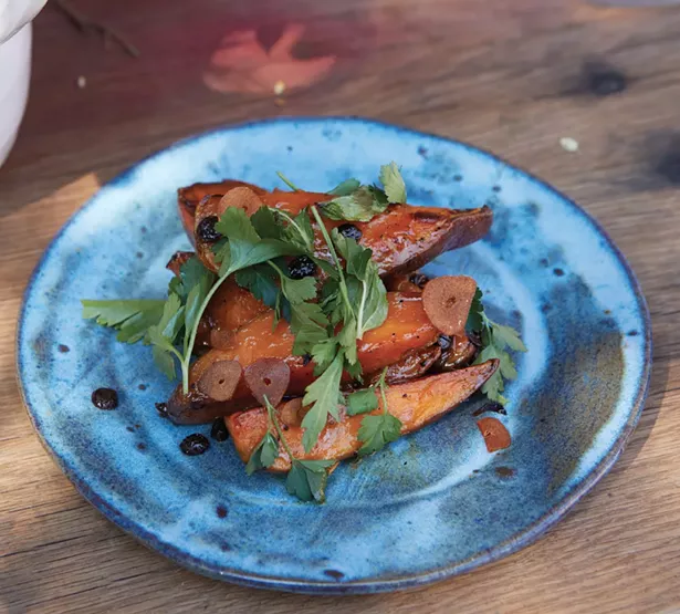 Roasted sweet potatoes with anchovy vinaigrette, currants, and parsley.