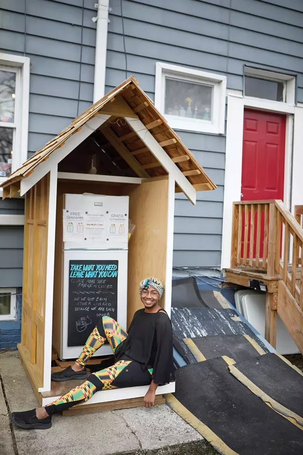 City Council candidate Justice McCray behind Binnacle Books with the community fridge that they help found. - DAVID MCINTYRE