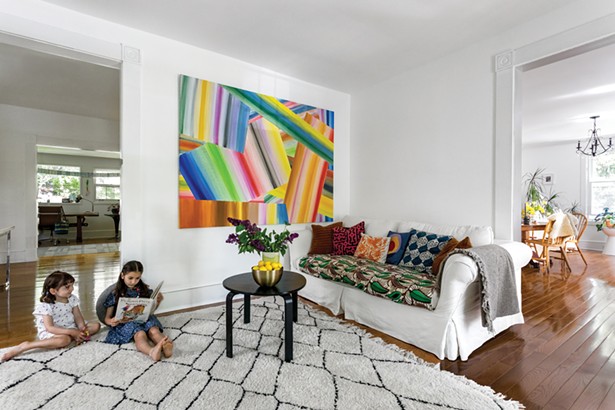 The children enjoying a calm moment in the home’s living room. The abstract painting is by Sam Schonzeit. Winick re-covered the family’s hand-me-down couch with Congolese textiles gifted from a friend, and decorated it with pillows from Hungary and Mexico and quilted pieces created by her mother-in-law. - WINONA BARTON-BALLENTINE
