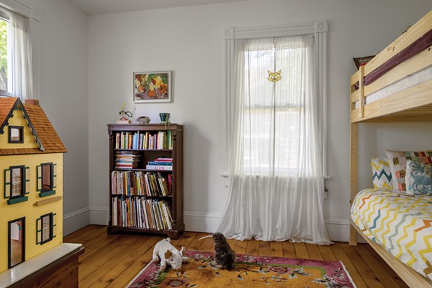 The second-floor children’s bedroom showcases the home’s pine plank flooring. Winick found a second-hand dollhouse for her daughters and hung a painting by their paternal great grandmother Edith Horton—a Viennese refugee and prolific painter who died last year at the age of 99. - WINONA BARTON-BALLENTINE
