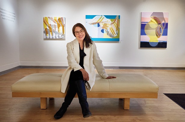 Carrie Chen in front of paintings by Ginnie Gardiner in the Carrie Chen Gallery. - DAVID MCINTYRE