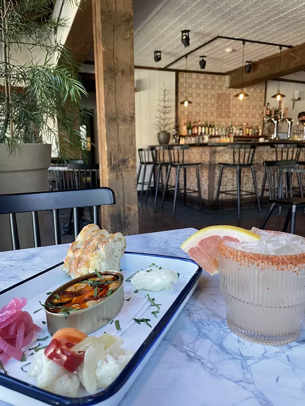 Conservas served with pickled onions, giardiniera, and housemade foccacia and a grapefruit margarita