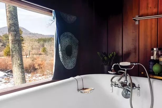 The first-floor bathroom has one of the home’s best views of nearby Mt. Tobias. Jones replaced her father’s copper tub with a vintage claw foot bath. She purchased the curtain on a trip to Kyoto with Dzongsar Khyentse Rinpoche, who she’s worked for since 2001. - WINONA BARTON-BALLENTINE