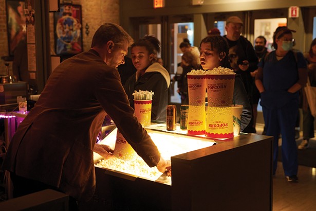 Christian Larson filling a bucket of popcorn at Story Screen movie theater on Main Street. - DAVID MCINTYRE
