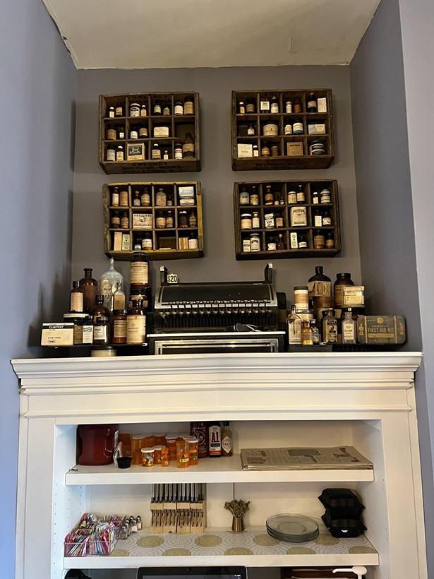 A vintage cash register and assorted bottles fill the shelves in the upstairs lounge at Pharmacy Kitchen & Bar in Goshen. - PHOTO BY FRANZ BRENDLE