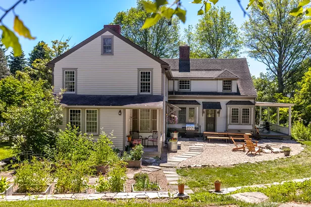 A rear view of the Reisfeld home, formerly the Elling’s Guest House. The Reisfelds worked with Stephen Fitch of Fitch Landscaping and Jesse Bunce of Bunce Property Services to transform an overgrown lawn space that had been plagued by invasive species into an inviting backyard and patio space. They chose pea gravel to surround the fire pit and raised-bed gardens, and created walkways out of stone salvaged from a former patio. Fitch also helped rebuild the property’s original stone retaining wall. - WINONA BARTON-BALLENTINE