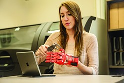 A New Paltz student working with a 3D printed robohand, designed and built at SUNY New Paltz's Hudson Valley Advanced Manufacturing Center. - SUNY NEW PALTZ