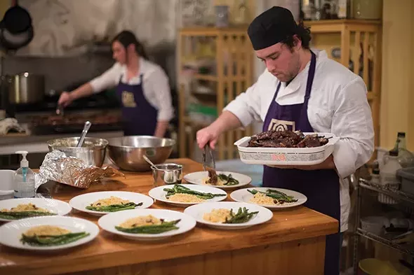 Chef Rob Handel and Farm Manager Amanda Hughes plating slow-roasted pomegranate molasses glazed lamb breast ribs - JIM MAXIMOWICZ