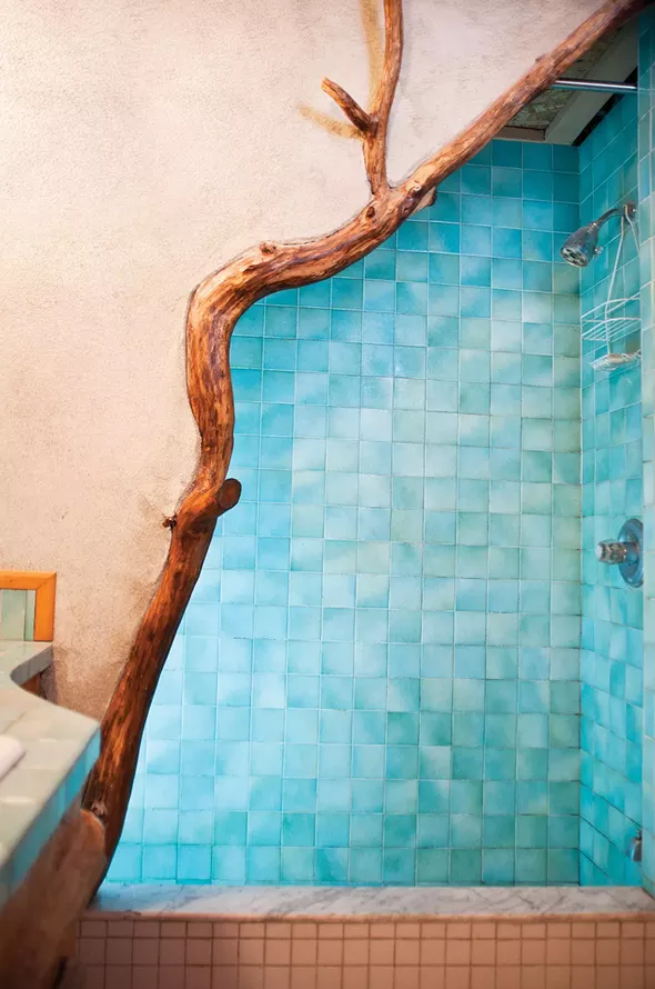 The downstairs shower made of blue tile and branches. "We tried to bring into the house as many of the materials that grow on the land as possible." - DEBORAH DEGRAFFENREID