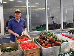 John, a volunteer at People's Place, works the front of the line for the Farm Stand every Tuesday.