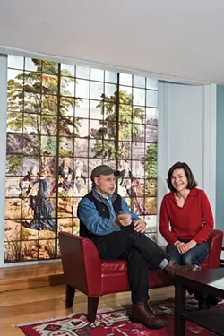 Franc Palaia and Eve D’Ambra in front of their 19th-century stained-glass window, depicting a fete galante—a French courtship party. A second layer of windows protects the glass from outside and Palaia added another layer of Plexiglass behind that. “You could throw a brick at it and it wouldn’t break,” he says.