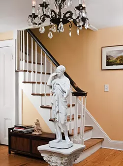 The home’s foyer dates from the 19th century and has low ceilings. “The chandeliers came with the house,” Palaia explains. An antique statue depicting a Roman woman was collected by D’Ambra. Placed under the chandelier, it keeps guests from hitting their heads.