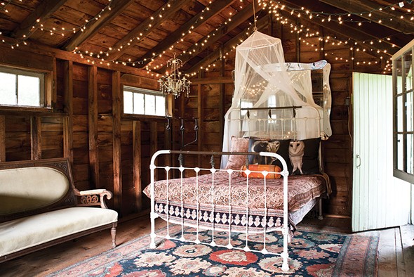 An iron bed in the outbuilding is decorated with Shaff’s owl portraits printed on pillows. - DEBORAH DEGRAFFENREID