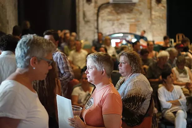 Nearly 150 people attended the discussion at Basilica, including Hudson Mayor Tiffany Martin (in pink shirt). - JOHN GARAY