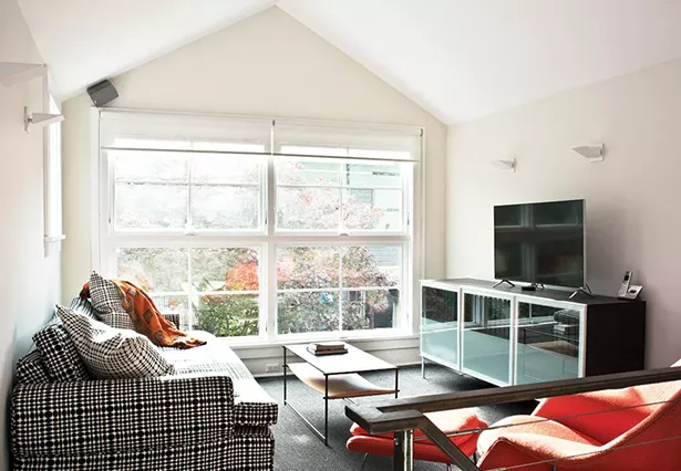 Smith added awning windows in the back of the house overlooking the garden, deck, and carriage house. The windows give a feeling of open space to both floors. “Even in a rainstorm we can keep the windows open and feel the outside,” Smith says. - DEBORAH DEGRAFFENREID
