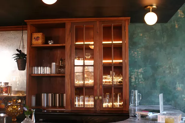 Neon tubes backlight the cabinets, which were custom built around vintage doors found at Zaborski's emporium to match the original wooden bar. - MARIE DOYON